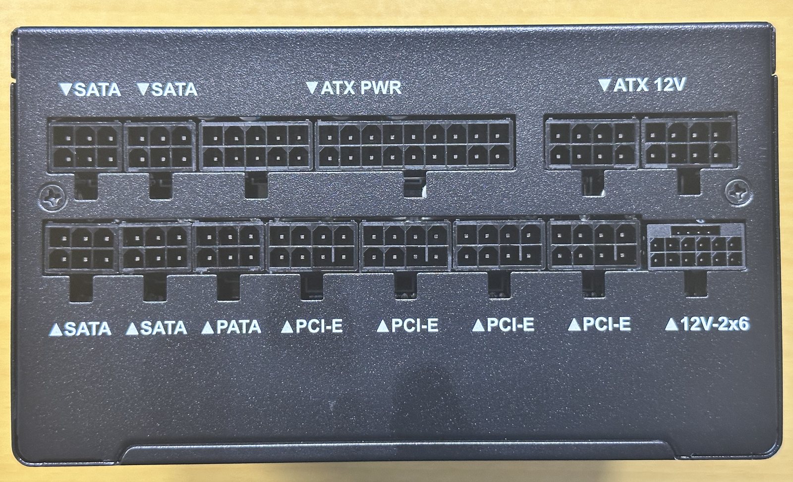 電源本体のケーブル差し込み口。SATA、PATA、PCI-E、ATX PWR、ATX 12V、12V-2x6の刻印がある
